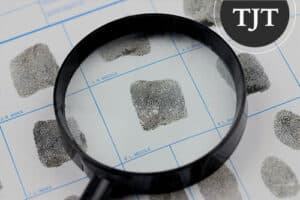 Magnifying glass examining a latent fingerprint on a fingerprint card in a New Jersey criminal case